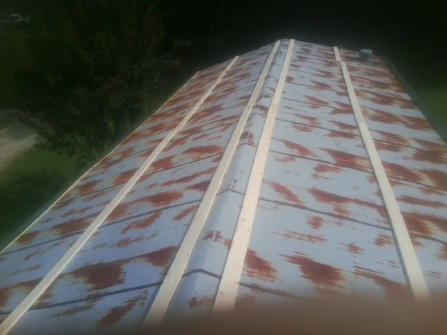 Rusted metal roof panels with new wood purlins before replacement — Storm Damage Roof Repair in Antimony by Roofing Brothers