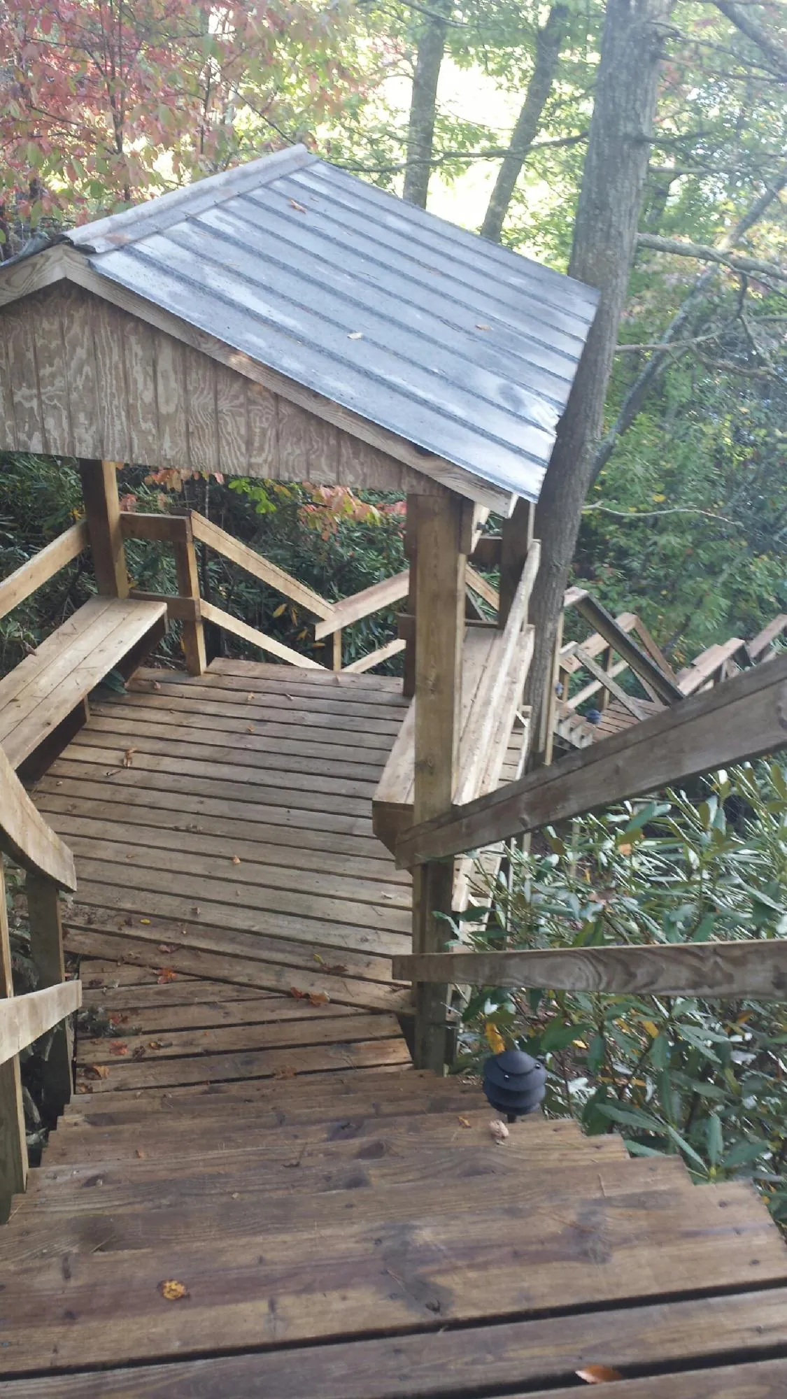Metal roofed shelter over wooden steps on a wooded walkway — Skylight Repair & Installation work by our crew in Antimony