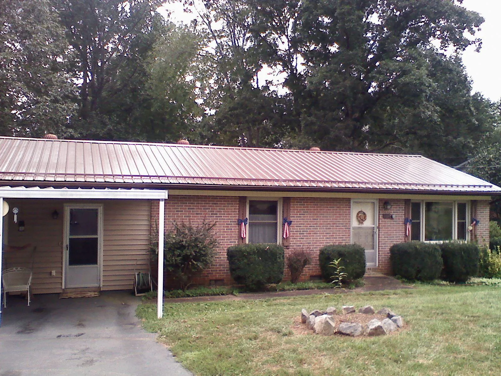Bronze metal roof and carport on a brick ranch home — Roof Repair work by our crew in Antimony